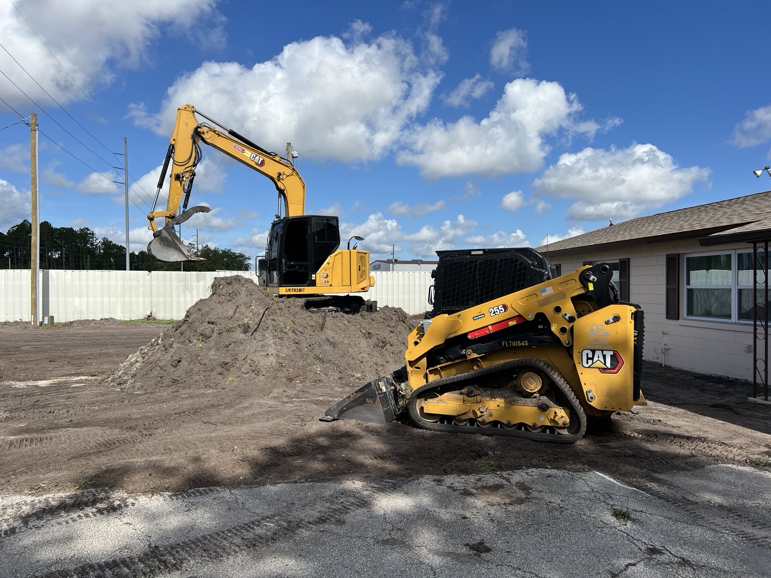 CAT excavator and skid steer grading site